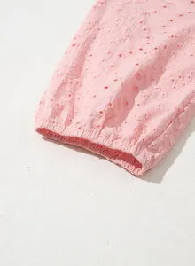 Detaillierte Nahaufnahme des pinkfarbenen Ärmels mit Lochstickerei und elastischem Bund