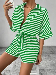 Close-up detail of green and white striped romper with button collar and belt.