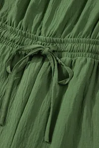 Detail view of green crinkle fabric romper with elastic waist and drawstring tie