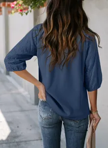 Detailansicht der Rückseite einer blauen Waffelstrickbluse mit bestickten Puffärmeln