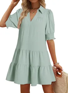 Detail of a sage green tiered mini dress featuring smocked sleeves and a collared V-neckline
