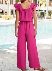 Back view of a vibrant fuchsia ruffled sleeve jumpsuit at a sunny luxury poolside