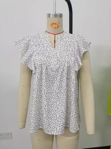 Detailansicht einer weißen Polka-Dot-Chiffonbluse mit Volantärmeln und tiefem V-Ausschnitt.