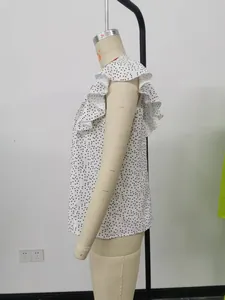 Detailansicht eines weißen ärmellosen Polka-Dot-Chiffon-Tops mit eleganten Rüschenschultern