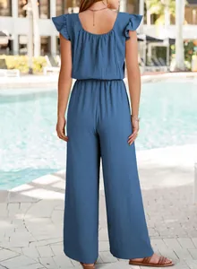 Back view of blue textured pleated jumpsuit featuring ruffle sleeves and wide leg design.