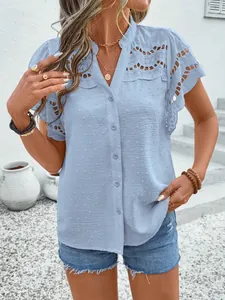 Detail view of light blue Swiss dot blouse with lace eyelet patterns and buttons