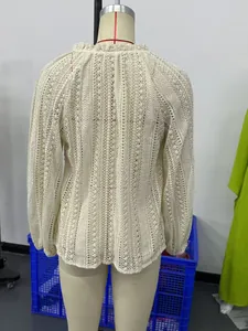 Vue détaillée du dos d'un chemisier à manches longues en dentelle ajourée crème sur mannequin