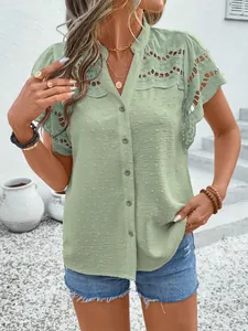 Model wearing a sage green lace hollow-out button short-sleeve top in outdoor setting