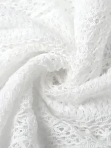 Gros plan de la texture du tissu en dentelle évidée blanche aux motifs complexes