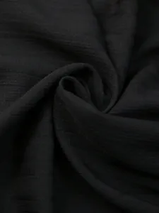 Close-up detail van zwarte ademende stoftextuur voor etnische damesoverhemden