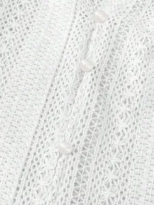 Gros plan détaillé du tissu en dentelle ajourée blanche avec des boutons nacrés
