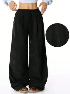 Close-up detail of black corduroy wide-leg pants featuring high waist and drawstring closure