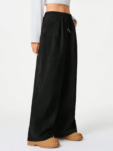 Close-up detail showing the texture and drawstring of black corduroy wide-leg pants