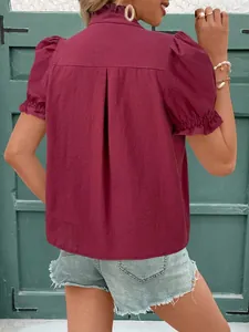 Vue arrière d'une blouse en coton bordeaux avec col à volants et manches bouffantes