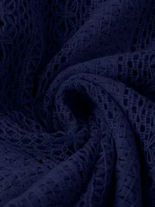 Gros plan sur la texture du tissu en dentelle creuse bleu marine du chemisier
