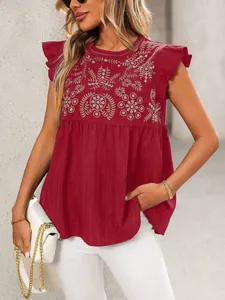Detailoverzicht van etnisch bloemig borduursel op een wijnrode damesblouse met vlindermouwen