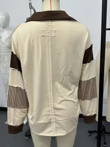 Back view of cream loose sweatshirt with brown striped sleeve detail and raw edges