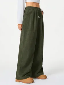 Detailed view of dark green high-waisted corduroy wide-leg pants with drawstring.