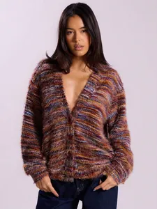 Professional model wearing a fuzzy multi-colored striped knit cardigan with deep V-neck buttons
