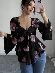 Primo piano di una blusa floreale in stile francese con scollo quadrato e fiocco sul davanti.