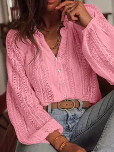 Vue détaillée de la dentelle rose ajourée et des boutons de la chemise à col V