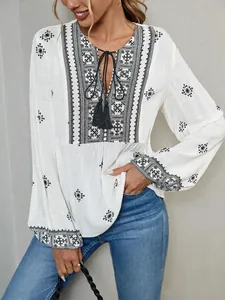Detail shot of a white vintage ethnic embroidered blouse with tie neck and lantern sleeves