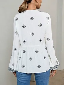 Back view of a white vintage ethnic blouse with black embroidery and lantern sleeves