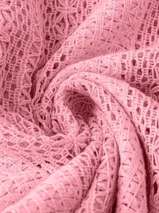 Gros plan détaillé de la texture du tissu en dentelle rose ajourée d'un chemisier