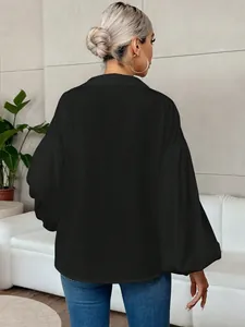 Πίσω όψη μιας κομψής μαύρης μακρυμάνικης μπλούζας με πολύ κομψά φουσκωτά μανίκια