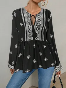Close-up of retro ethnic style blouse with V-neck tie-front and geometric patterns