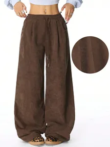 Close-up showing the ribbed corduroy fabric texture and loose fit of brown pants