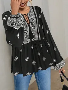 Detail of vintage ethnic style black blouse with lantern sleeves and tassel tie neck