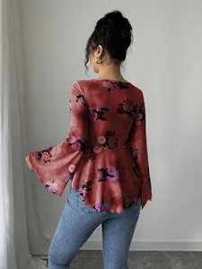 Vista posteriore di una blusa floreale rossa con maniche svasate e orlo a peplo.