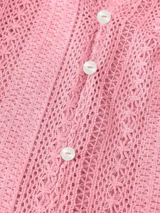 Détail macro d'une chemise rose en dentelle ajourée avec motifs au crochet et boutons