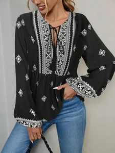 Close-up detail of vintage boho ethnic print blouse with tassel tie-neck and lantern sleeves