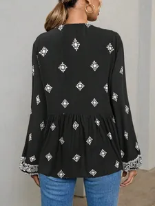 Detail view of the back of a black ethnic print blouse with embroidered lantern sleeves