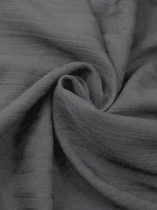 Detailopname van de ademende grijze kreukelstoftextuur van deze blouse in etnische stijl