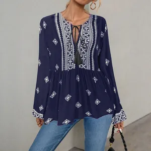 Bohemian navy blue tunic with ethnic embroidery, tassel tie-neck, and lantern sleeves.