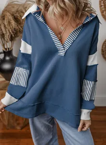 Close-up detail of a deep V-neck striped patchwork loose blue long sleeve sweatshirt