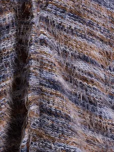 Close-up detail of multi-color fuzzy knit fabric on a retro Maillard style cardigan