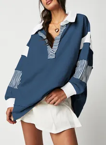 Detail view of oversized deep V-neck sweatshirt featuring blue striped patchwork sleeves.