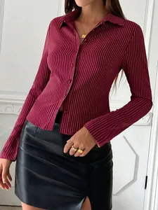 Detail of a burgundy striped long-sleeve button-down shirt paired with a black skirt.