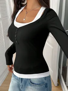 Detail of a black fake two-piece long-sleeve top with buttons and a white collar layer