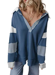 Woman wearing a loose fit deep V-neck sweatshirt with striped colorblock long sleeves