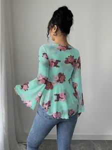 Vista posteriore dettagliata di una camicetta verde menta a fiori con maniche a campana