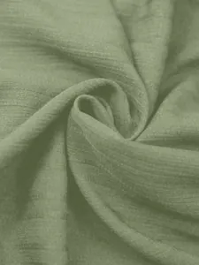 Detailweergave van de zachte geribbelde textuur van de saliegroene casual dameshemdstof.