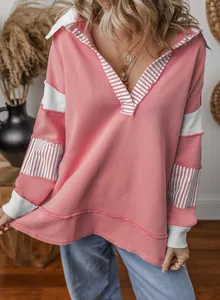 Detailed view of a pink color-block sweatshirt with striped V-neck and loose fit