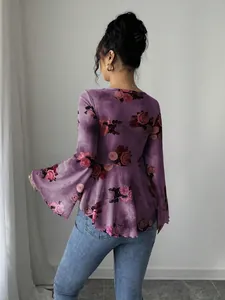 Vista dettagliata della camicetta viola a fiori tie-dye con eleganti maniche a campana.