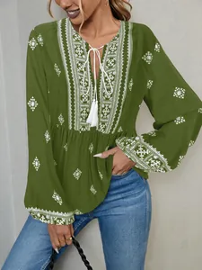 Detail of olive green ethnic blouse with white embroidery and tassel tie.