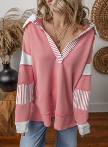 Casual oversized pink sweatshirt featuring deep V-neck and striped patchwork detail on model